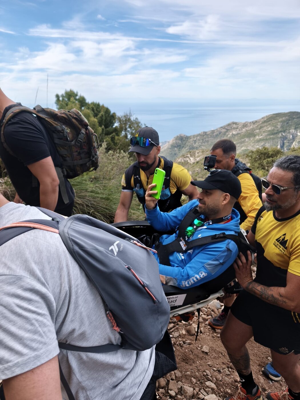 Silla Joëlette guiada por porteadores en la sierra, con vistas al mar